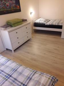 a bedroom with a white dresser and a bed at Cottage am Wald bei Berlin in Falkensee