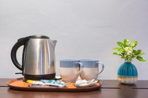 a tea kettle and two mugs on a table at Mira Montra Resort Koh Mak - SHA Plus in Ko Mak