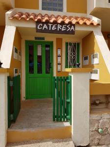 a building with a green door and a cafe at Cateresa Apartament in Santa Maria