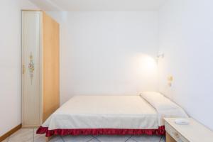 a bedroom with a white bed with a red skirt at Nuova Aurora in Marghera