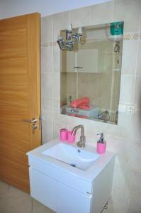 聖瑪麗亞的住宿－Cateresa Apartament，浴室设有水槽、镜子和粉红色杯子