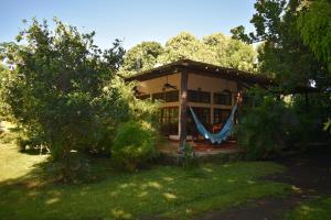 a small house with a hammock in the yard at Los Cocos, Chinandega in Chinandega