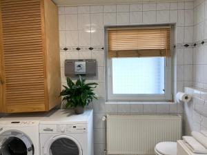 eine Küche mit einer Waschmaschine und einem Fenster in der Unterkunft Privatquartier im Ortskern von Westerstede in Westerstede