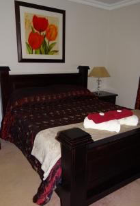 a bedroom with a bed with a red bedspread at Europa Lodge in Welkom