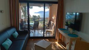 a living room with a couch and a view of the ocean at Studio cabine vue mer, piscine panoramique, parking couvert in Cannes