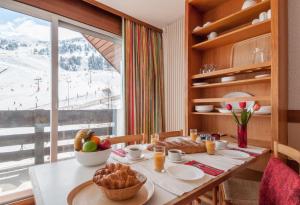 a dining room table with a view of a ski slope at Résidence Pierre & Vacances Les Bleuets in Méribel