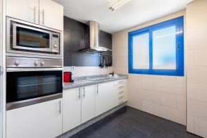 a kitchen with white cabinets and a window at iloftmalaga Ático Pacífico 19 B in Málaga