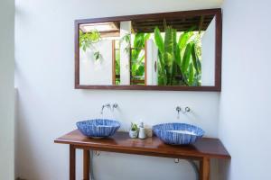 a bathroom with two sinks and a mirror at Mira Montra Resort Koh Mak - SHA Plus in Ko Mak