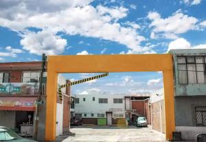 an orange archway in a parking lot between buildings at Hotel Plaza Aleman in Le&oacute;n