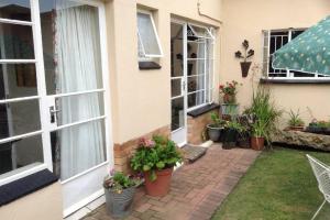 a house with potted plants on the side of it at Clarens Socialites Garden Apartment #2 in Bethlehem