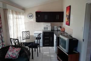 a small kitchen with a table and a microwave at Clarens Socialites Garden Apartment #2 in Bethlehem