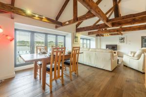 a dining room and living room with a table and chairs at Copperhouse View in Hayle