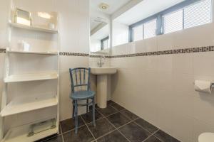 a bathroom with a blue chair and a sink at Copperhouse View in Hayle +19 photos