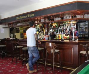 a man standing in front of a bar at Prince of Wales in East Cowes