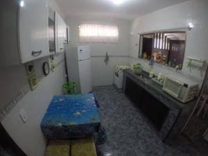 a small kitchen with a sink and a refrigerator at Paraíso Casa de Praia em Saquarema in Saquarema