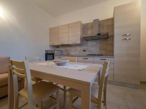 a kitchen with a wooden table and chairs at Tilibbas Bay Flat - Klodge in Olbia
