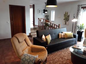 a living room with a couch and a chair at Casa Branca do Moinho in Salgueiro
