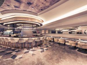 a restaurant with a bar with stools at Mercure Hangzhou West Lake in Hangzhou