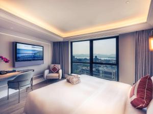 杭州市にあるMercure Hangzhou West Lakeの大きなベッドと大きな窓が備わるホテルルームです。