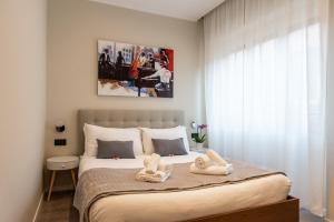 XXIV Domus Luxury Suites في روما: غرفة نوم عليها سرير وفوط