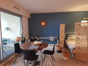 una habitación con una mesa y sillas y una cama en Face mer Tyra, en La Baule