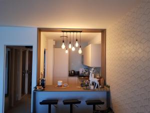 cocina con encimera con taburetes y espejo en Face mer Tyra, en La Baule 4 fotos más