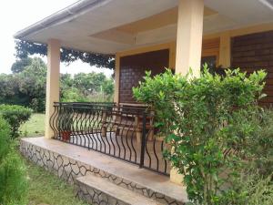 un porche con un banco en una casa en Plastic Bottles House en Entebbe