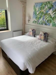 - une chambre avec un grand lit blanc et 2 oreillers dans l'établissement Apartamentos La Bicicleta, à Puente Viesgo
