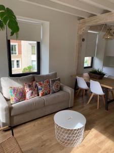 - un salon avec un canapé et une table dans l'établissement Apartamentos La Bicicleta, à Puente Viesgo