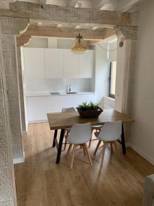 comedor con mesa de madera y sillas en Apartamentos La Bicicleta, en Puente Viesgo