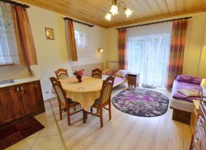 a kitchen and living room with a table and a couch at Willa Modrysówka in Zawoja