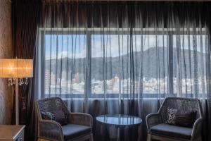 a room with two chairs and a large window at Century Plaza Hotel in Tokushima