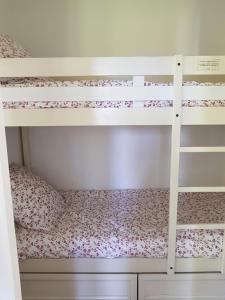 a bedroom with two bunk beds with pink flowers at appartement domaine de Bordaberry Urrugne in Urrugne