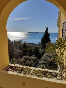 an arched window with a view of the ocean at Apartments Pinezić in Martinšćica