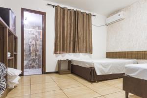 um quarto de hospital com uma cama e uma janela em Hotel Holiday Foz em Foz do Iguaçu