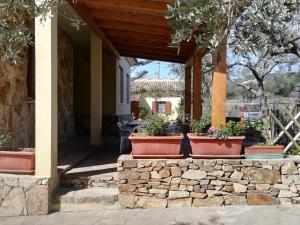 a porch of a house with potted plants on it at Villa San Gavino in Budoni