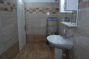 ein Bad mit einem Waschbecken und einem Spiegel in der Unterkunft Daniel's Apartment in Sarandë