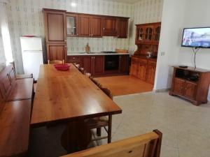 ブドーニにあるVilla San Gavinoの木製テーブルとテレビ付きの広いキッチンが備わります。