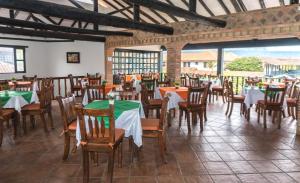 a restaurant with tables and chairs in a room at Hotel Andres Venero in Villa de Leyva