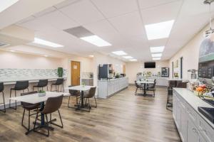 a cafeteria with tables and chairs and a kitchen at Quality Inn & Suites in Lake City