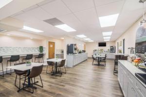 a cafeteria with tables and chairs and a kitchen at Quality Inn & Suites Lake City in Lake City
