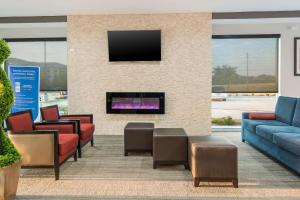 a lobby with couches and a fireplace with a tv at Comfort Suites DeSoto Dallas South in DeSoto