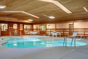 una piscina en un edificio con sillas y mesas en Quality Inn & Suites en Prairie du Chien