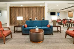 a living room with a blue couch and chairs at Comfort Suites DeSoto Dallas South in DeSoto