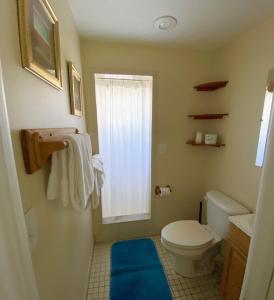a bathroom with a toilet and a window at Harborside Motel & Marina in Key West