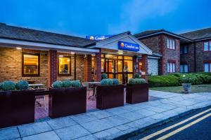 a hotel with tables and chairs outside of it at Comfort Inn Arundel in Arundel