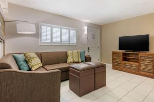 a living room filled with furniture and a tv at Seafarer Inn & Suites, Ascend Hotel Collection in Jekyll Island