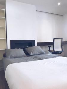 um quarto com uma cama e uma cadeira em New Apartament close to IFEMA-AEROPUERTO em Madri