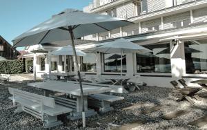 a picnic table and chairs with umbrellas in front of a building at Galery69 in Dorotowo