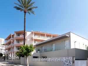 un palmier devant un bâtiment dans l'établissement Hotel Venecia Paguera, à Paguera